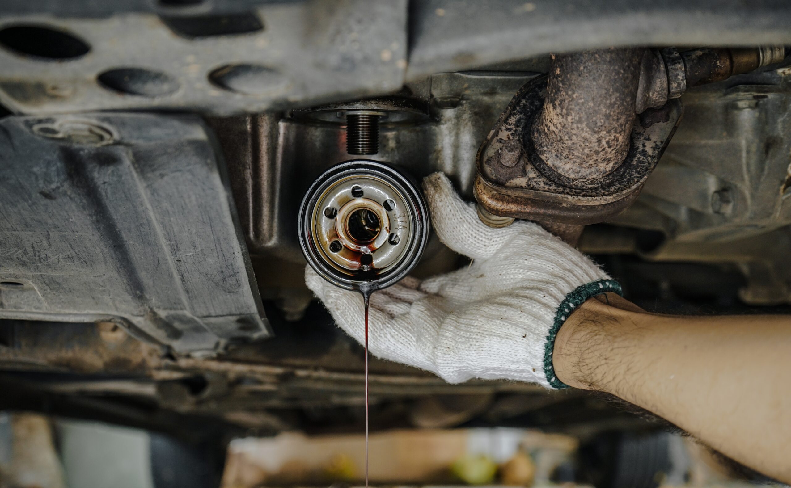 Close-up,Of,Auto,Mechanic’s,Hands,Removing,The,Underside,Oil,Filter Alternator Replacement on new engine